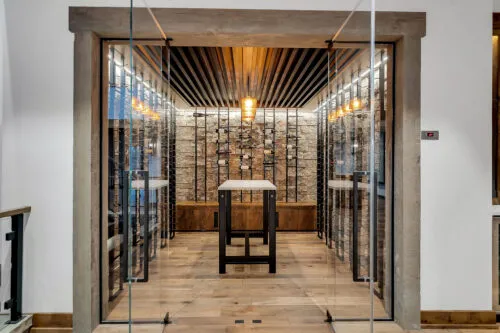 A Rustic glass enclosed wine room featuring W Series wine racks