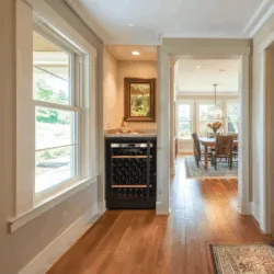 A modern living space with one small Transtherm wine fridge in custom millwork.